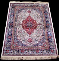 Lot 814 - A woven Kashmir rug, the central claret...