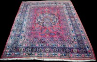 Lot 859 - A Mashad carpet, the central rosette on claret...