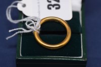 Lot 32 - A 22ct. yellow gold wedding band, ring size R,...