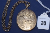 Lot 33 - A 9ct. yellow gold oval photograph locket with...