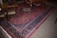 Lot 640 - A large 20th Century Persian carpet on red...