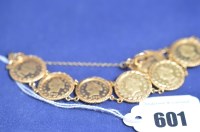 Lot 601 - A medallion/coin bracelet, set with eight...