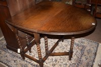 Lot 861 - A small oak oval gateleg dining table, raised...
