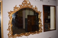 Lot 926 - A large modern shaped wall mirror in ornate...