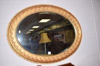 Lot 929 - A modern oval bevelled wall mirror in ornate...