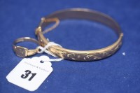 Lot 31 - A 9ct. yellow gold bangle with engraved...