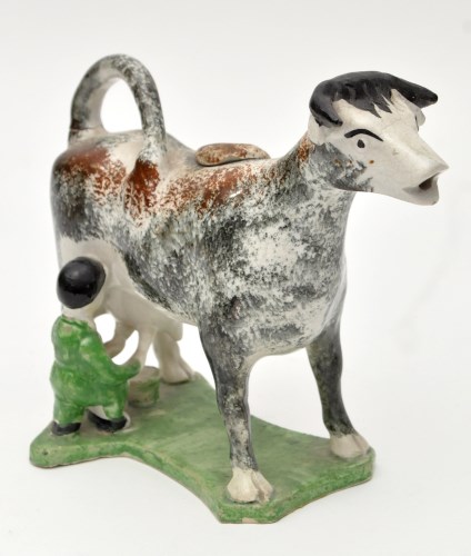 Lot 108 - Sponged earthenware cow creamer and cover of...