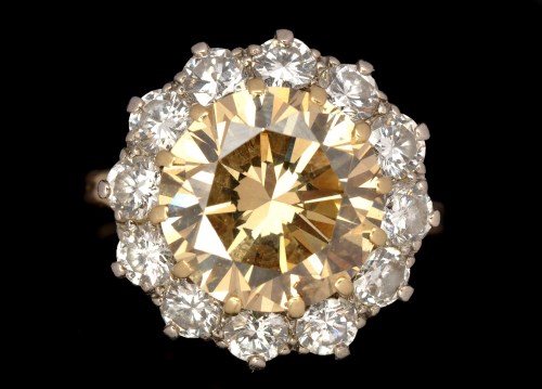 Lot 589 - A coloured diamond and diamond cluster ring,...