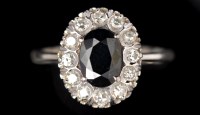 Lot 606 - A sapphire and diamond cluster ring, the oval...