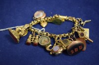 Lot 81 - A yellow metal charm bracelet of embossed...