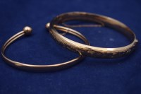 Lot 60 - Two 9ct. yellow gold bangles, one...