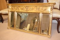 Lot 389 - A Regency style triptych wall mirror in gold...