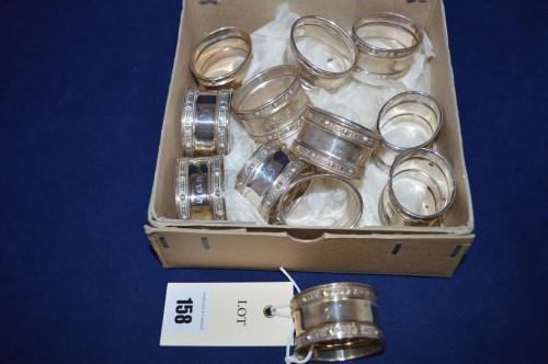 Lot 158 - A set of twelve silver napkin rings, by Reid &...