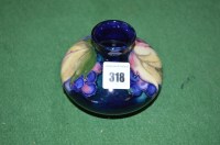 Lot 318 - A Moorcroft vase in berry patterrn, on dark...