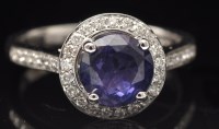 Lot 643 - A purple sapphire and diamond cluster ring,...