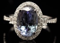 Lot 650 - A tanzanite and diamond cluster ring, the oval...