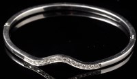 Lot 708 - A diamond bangle, the shaped front set with...