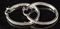 Lot 726 - A pair of diamond hoop earrings, set to front...