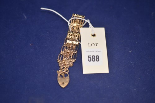 Lot 588 - A 9ct. yellow gold gate link bracelet with...