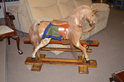 Lot 1030 - A hide covered rocking horse on painted wooden...