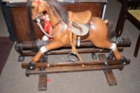 Lot 1031 - A modern rocking horse, the carved bay painted...