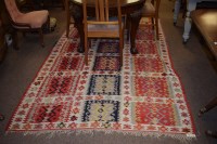 Lot 911 - A kilim rug with three rows of red and blue...