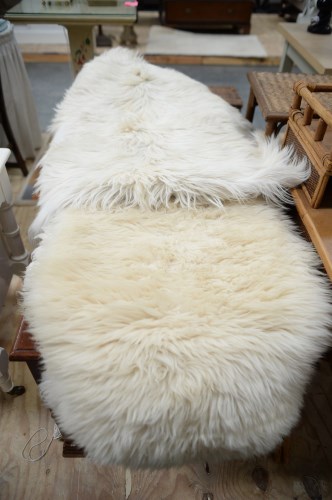 Lot 12 - Two double sheepskin rugs; and another rug,...
