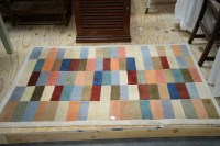 Lot 119 - A rectangular woollen rug in multi-coloured...
