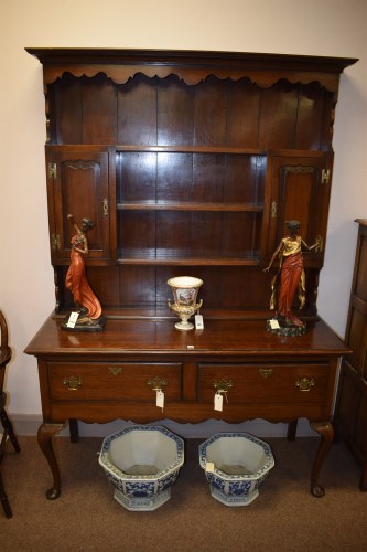 Lot 1135 - A Georgian stained oak dresser with panelled...