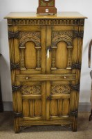 Lot 1138 - A reproduction oak cocktail cabinet, with...
