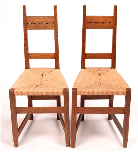 Lot 1020 - Manner of M.H. Baillie Scott: a pair of early 20th Century oak bedroom chairs