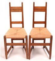 Lot 1020 - Manner of M.H. Baillie Scott: a pair of early 20th Century oak bedroom chairs