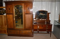Lot 1375 - An Edwardian inlaid mahogany bedroom suite, comprising: bevelled mirror centred wardrobe, 149 x 203cms high, together with a dressing table, and a bed head and footboard.