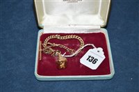 Lot 136 - A 9ct.  curb link watch chain with fob.