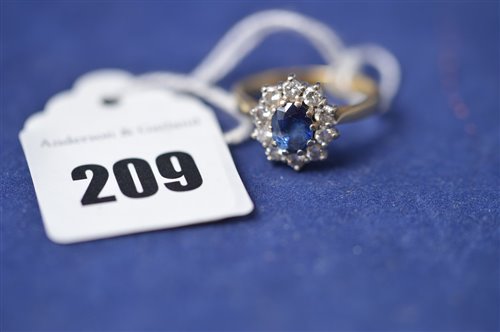 Lot 209 - A sapphire and diamond cluster ring.