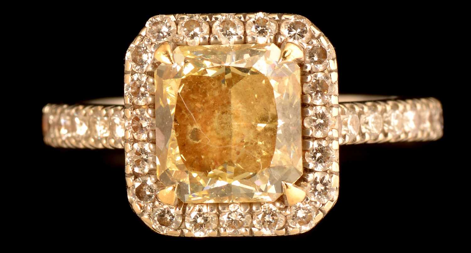 Lot 593 - Fancy light yellow diamond and diamond cluster ring