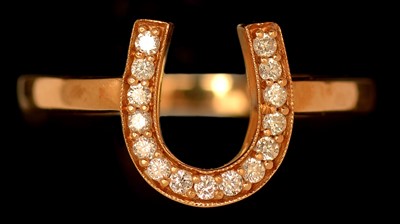 Lot 562 - Diamond horseshoe ring