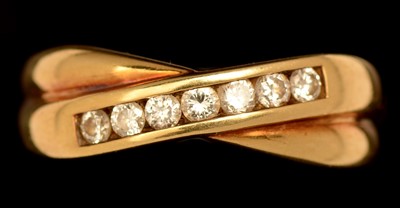 Lot 654 - A diamond crossover ring, the seven...