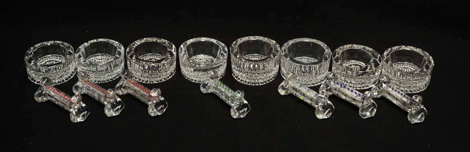 Lot 196 - A set of seven pressed and cut glass knife rests; and a set of eight table salts.