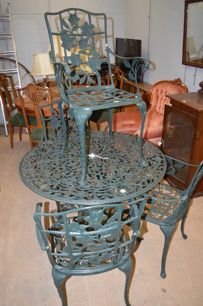 Lot 504 - A green cast iron garden table and four chairs.