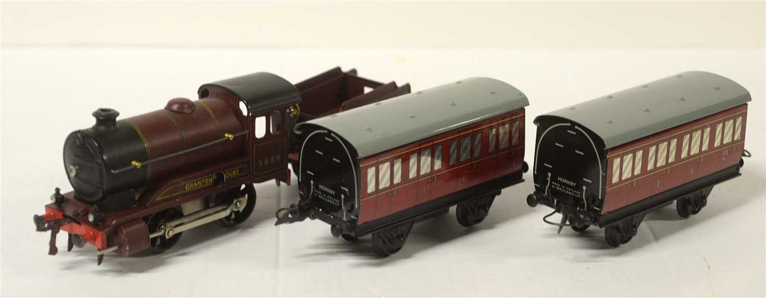 Lot 1386 - An 0-gauge clockwork 0-4-0 locomotive, tender and two tinplate coaches by Hornby
