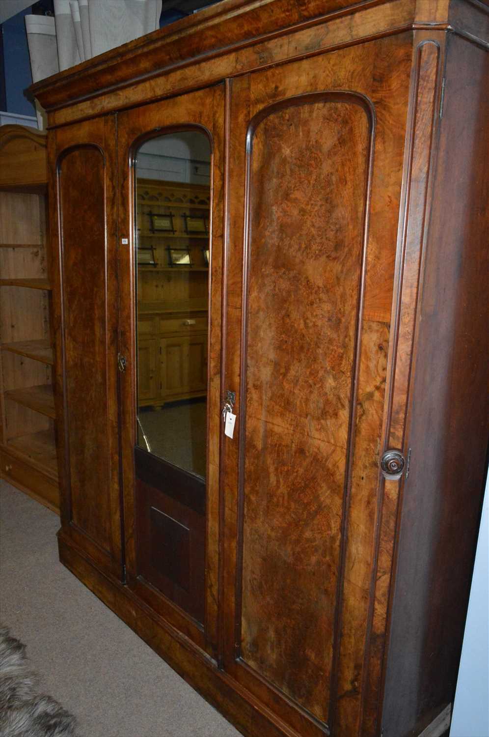 Lot 574 - A Victorian figured walnut three door wardrobe with centre mirror-panelled door