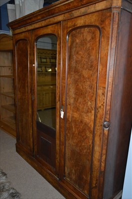 Lot 574 - A Victorian figured walnut three door wardrobe with centre mirror-panelled door