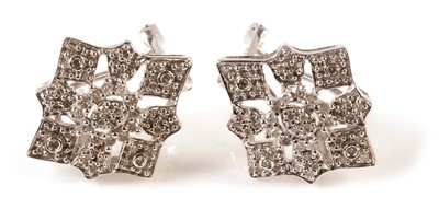 Lot 141 - A pair of diamond set snowflake pattern earrings