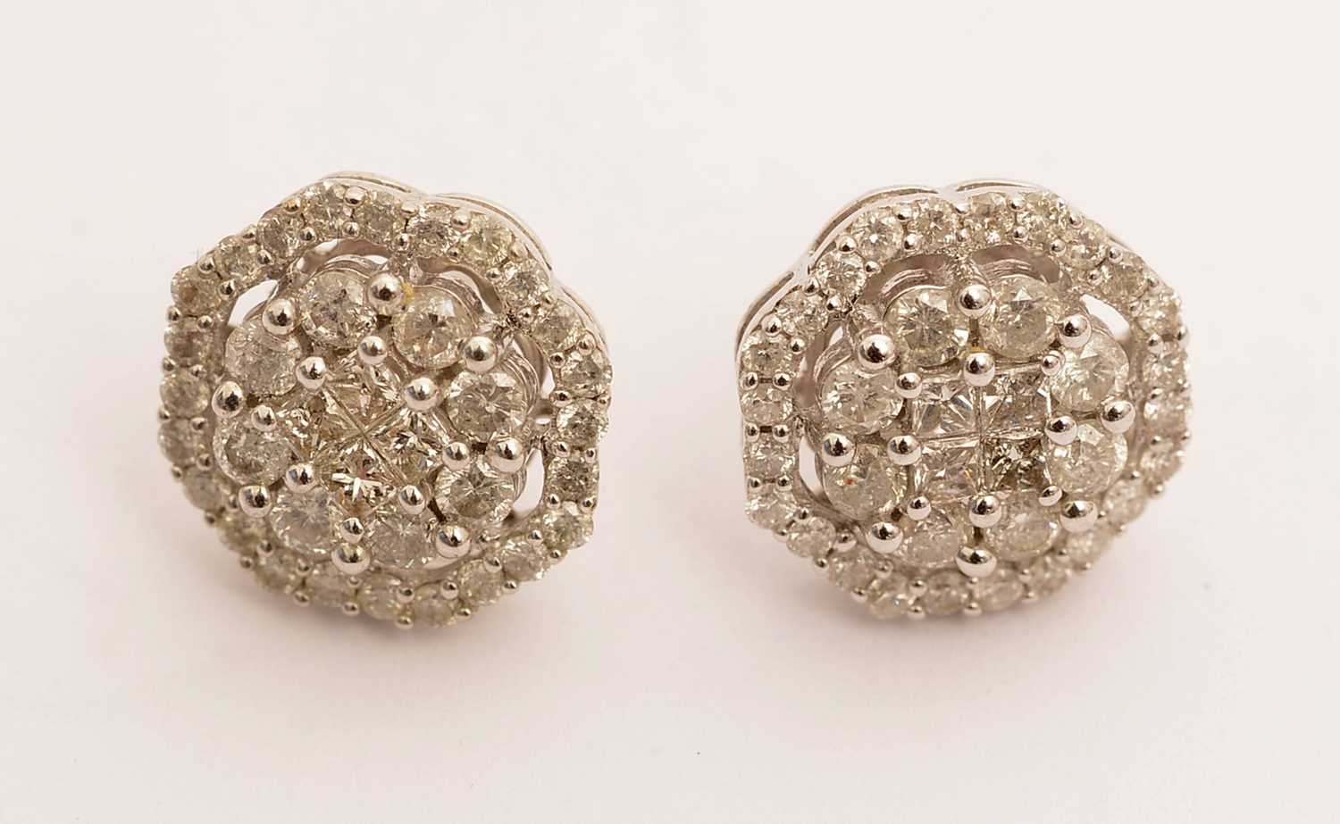 Lot 101 - A pair of diamond cluster earrings