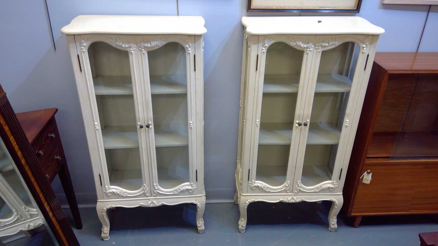Lot 644 - A pair of 20th Century cream painted display...
