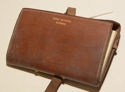Lot 710 - A cast wallet and contents; fishing reel
