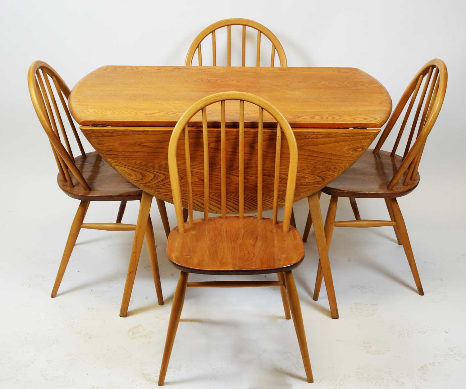 Lot 91 - Ercol - Blonde elm drop leaf dining table and four Windsor dining chairs