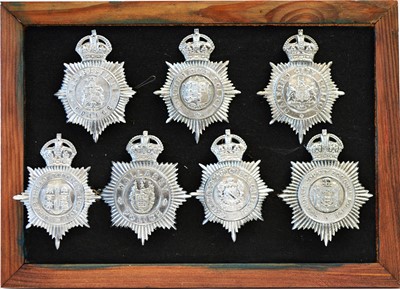 Lot 805 - A collection of 20th Century Police helmet badges, framed.