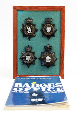 Lot 807 - A collection of 20th Century Police helmet badges, framed; and associated book.